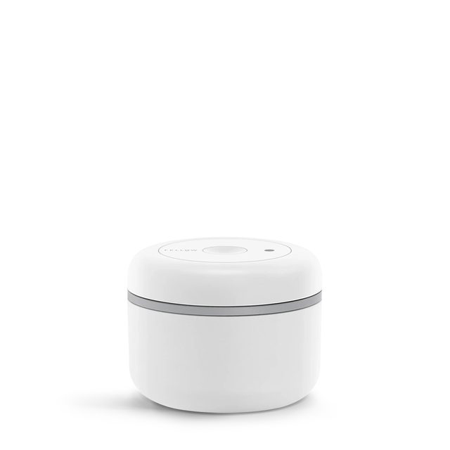 A short matte white Fellow Atmos vacuum canister with a gray band under its lid